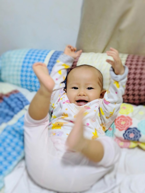 Retrato de uma menina bonita sorridente deitada na cama em casa
