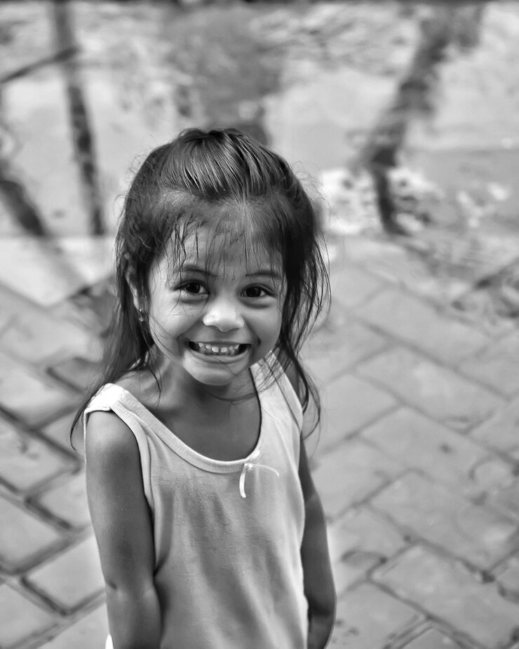 Foto retrato de uma menina bonita sorrindo enquanto está de pé na calçada
