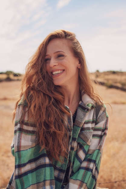Foto retrato de uma menina bonita sorrindo para a câmera com um campo ao fundo