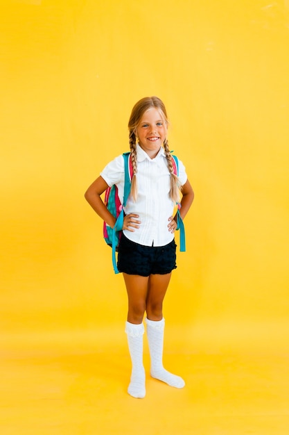 Retrato de uma menina bonitinha em um fundo amarelo.