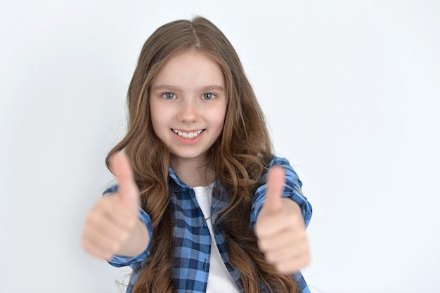 Foto retrato de uma menina bonitinha posando com o polegar para cima