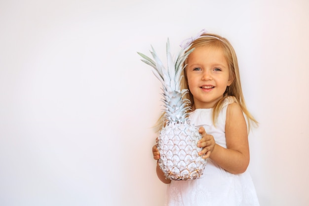 Retrato de uma menina bonitinha segurando abacaxi pintado em branco