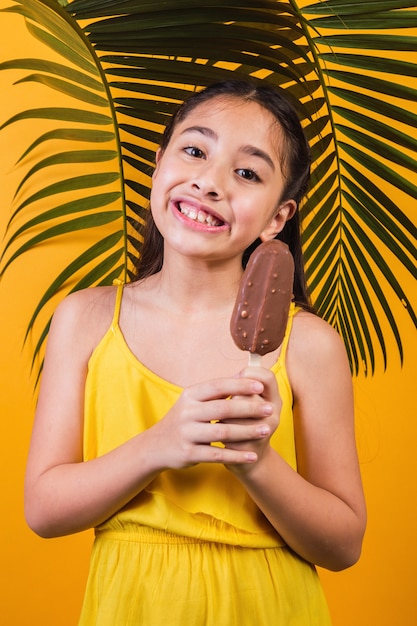 Retrato de uma menina bonitinha segurando um palito de picolé de chocolate.