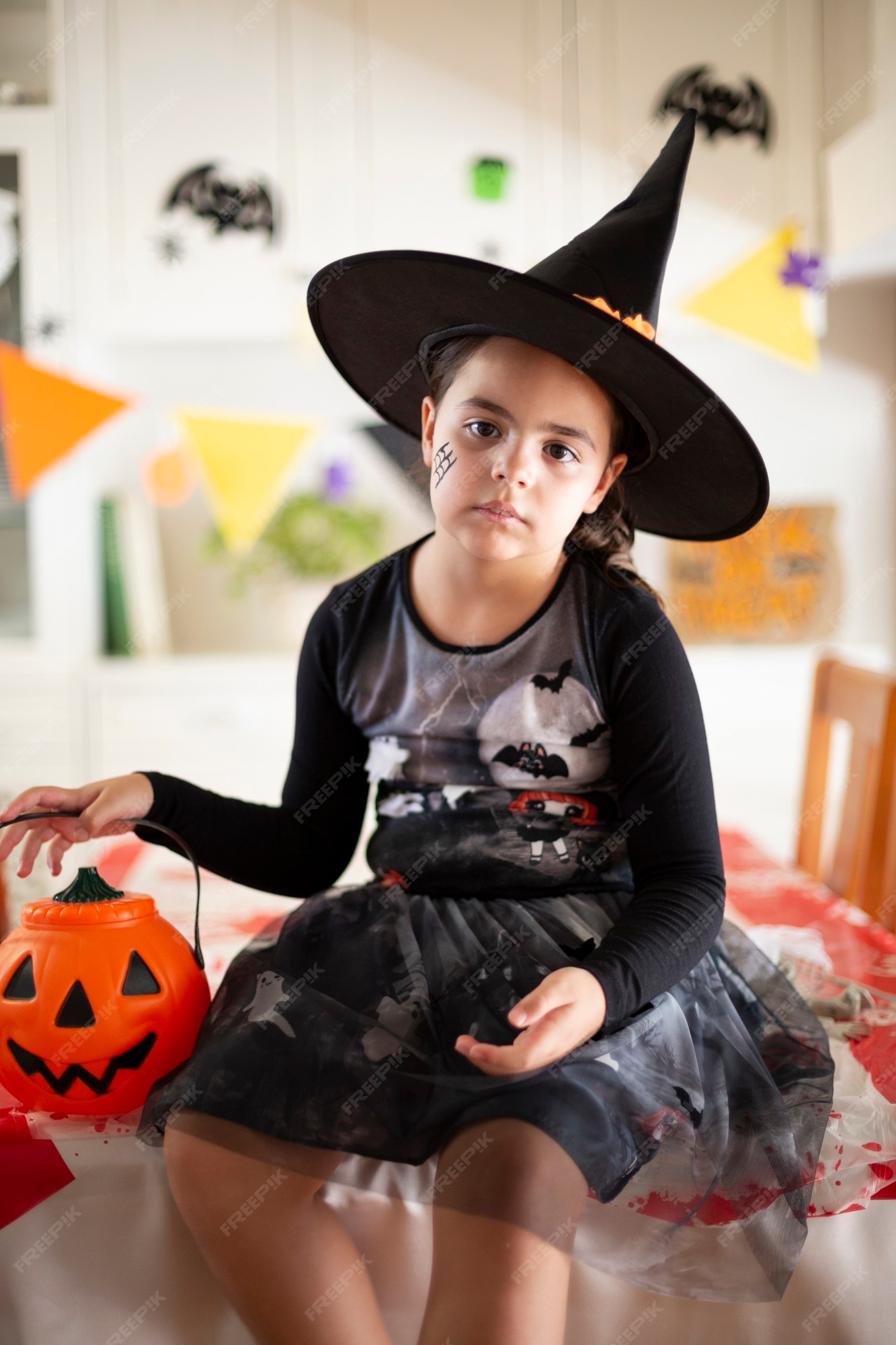 Uma Jovem Bruxa Bonita Em Um Chapéu Cônico Segura Uma Abóbora De Halloween  Em Suas Mãos E Faz Um Feitiço Com Sua Mão. Foto Royalty Free, Gravuras,  Imagens e Banco de fotografias.