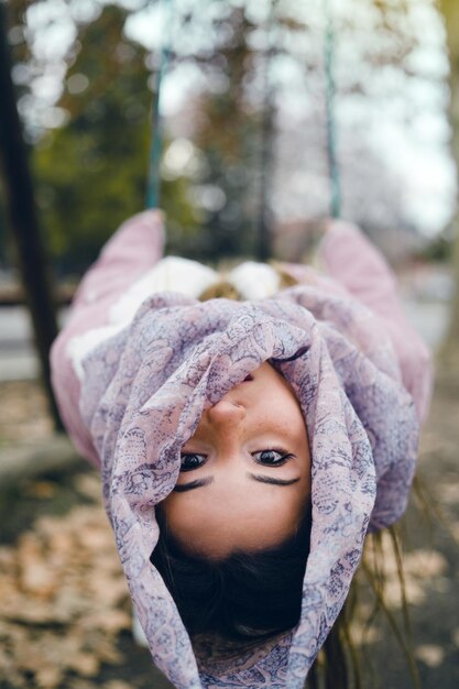 Retrato de uma menina chocada inclinada na floresta