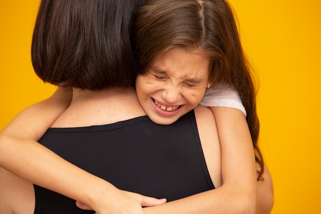 Retrato de uma menina chorando que está sendo realizada por sua mãe