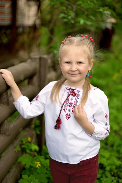 Retrato de uma menina com flores em uma camisa bordada ucraniana com Viburnum no cabelo