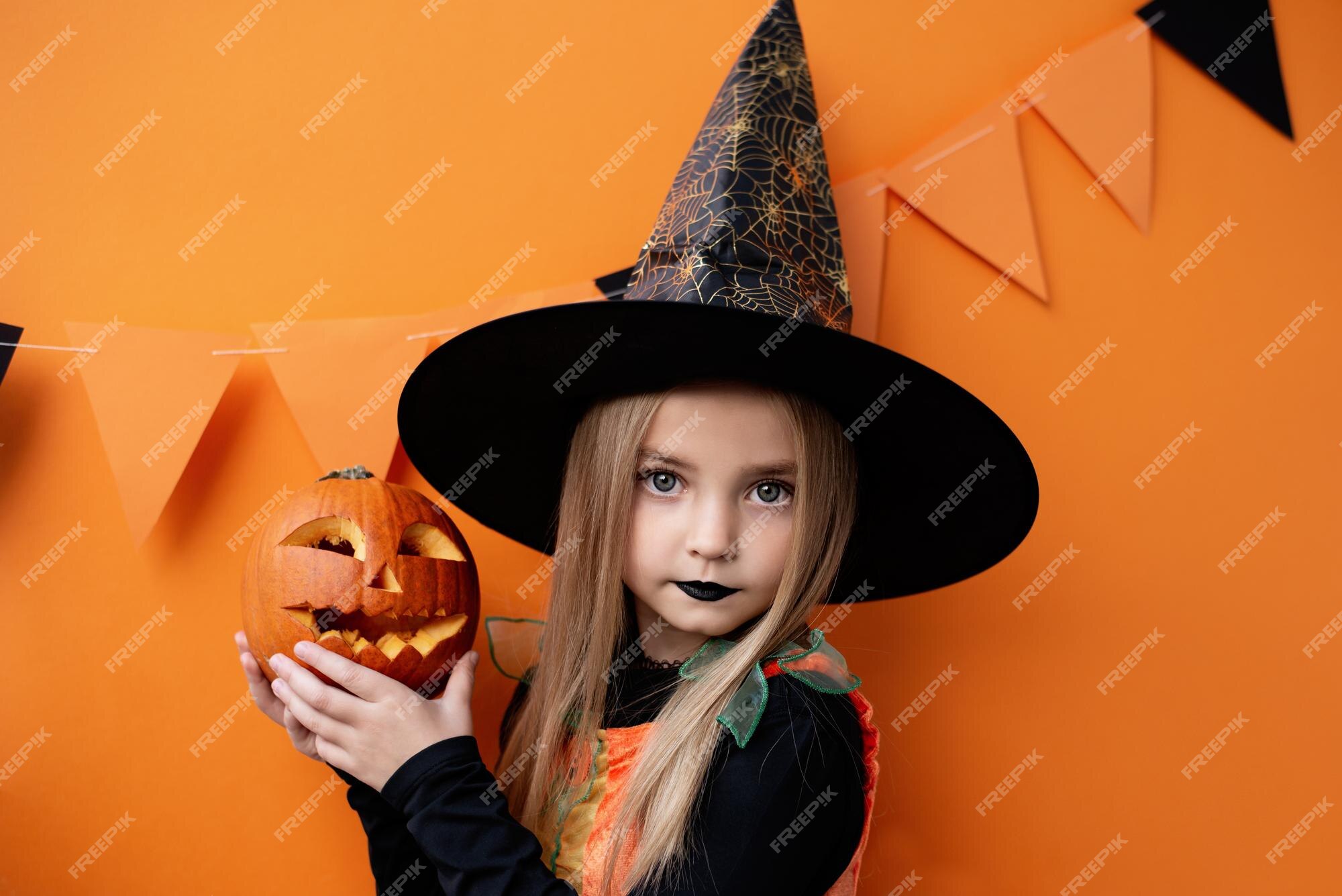 Retrato de menina pequena bonita em traje de halloween bruxa laranja preto  com vassoura. feliz dia das bruxas conceito. doçura ou travessura. festa de  crianças engraçadas, infância feliz.