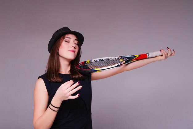 Retrato de uma menina com raquete de tênis e jogar como violino