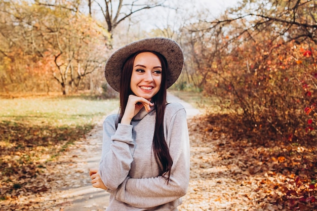 Retrato de uma menina com um chapéu em um parque de outono