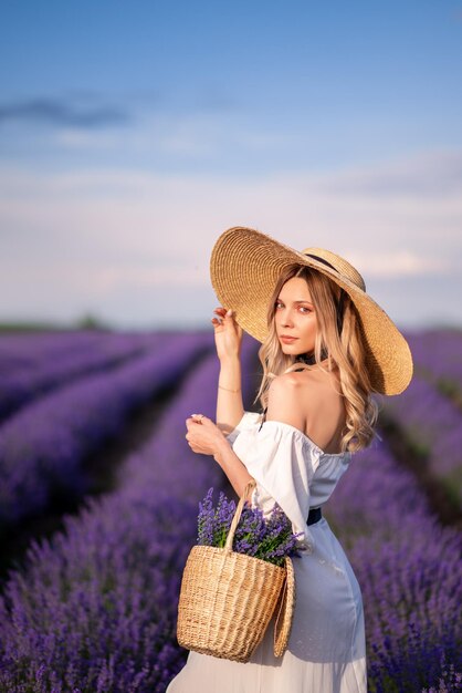 Foto retrato de uma menina com um vestido branco e um grande chapéu em um campo de lavanda provence