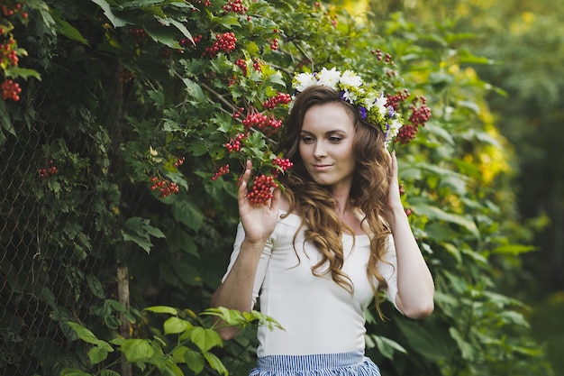 Retrato de uma menina com uma coroa de flores na cabeça no jardim 4798