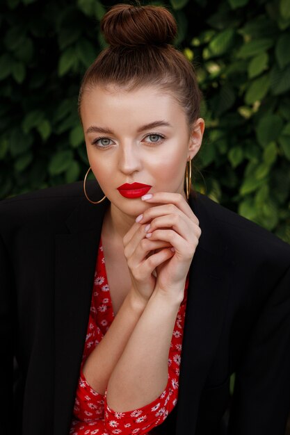 Retrato de uma menina com uma maquiagem linda. batom vermelho nos lábios. imagem de verão em uma festa