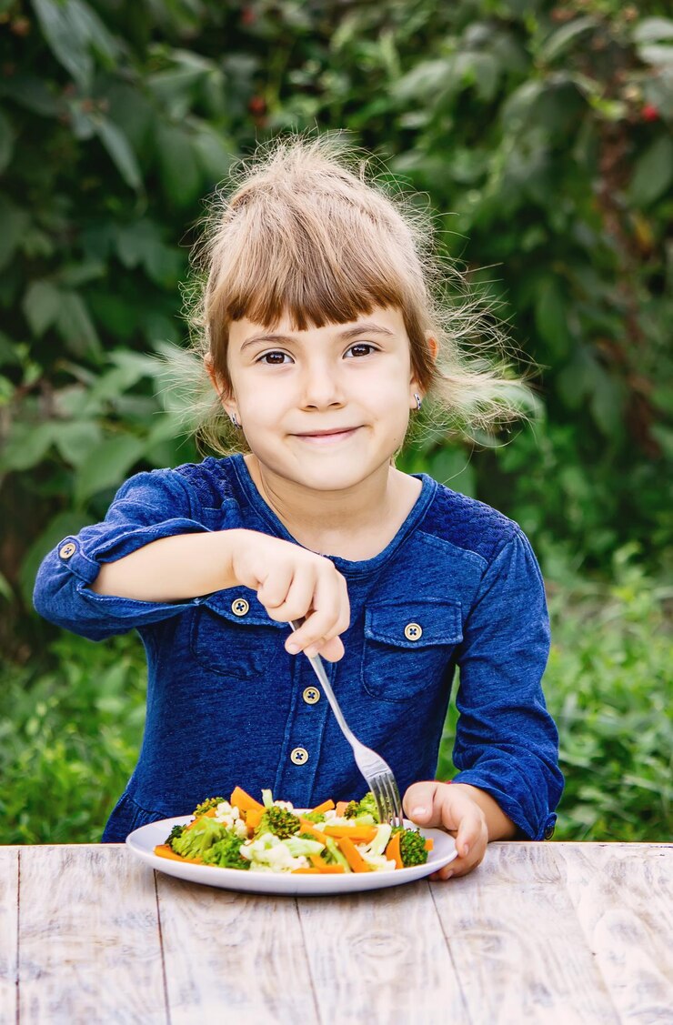 Foto retrato de uma menina comendo comida na mesa