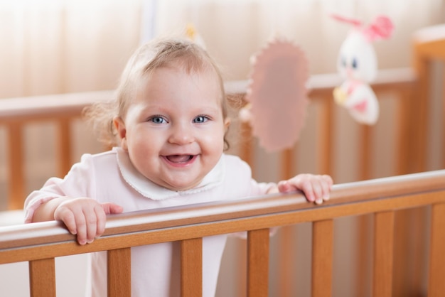 Foto retrato de uma menina criança feliz e rindo em um berço