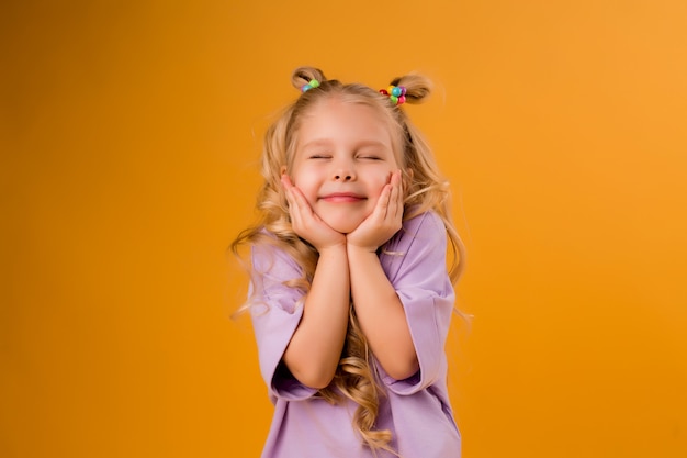 retrato de uma menina criança feliz isolar em um espaço amarelo, espaço para texto