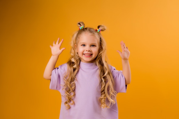 retrato de uma menina criança feliz isolar em um espaço amarelo, espaço para texto