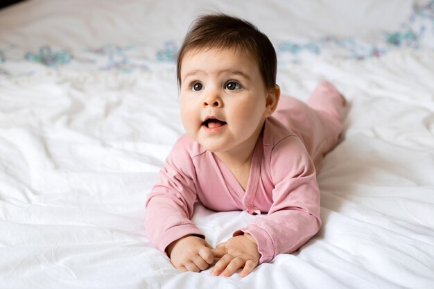 Retrato de uma menina criança sorrindo enquanto estava deitado na cama