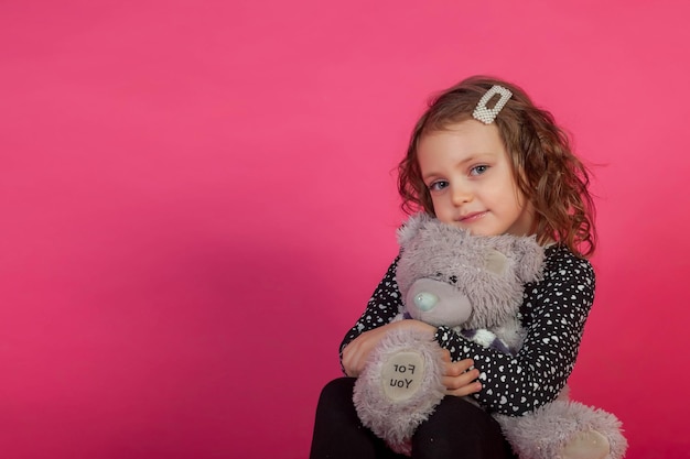 Retrato de uma menina de 56 anos de vestido em fundo rosa com inscrição de ursinho de pelúcia PARA VOCÊ