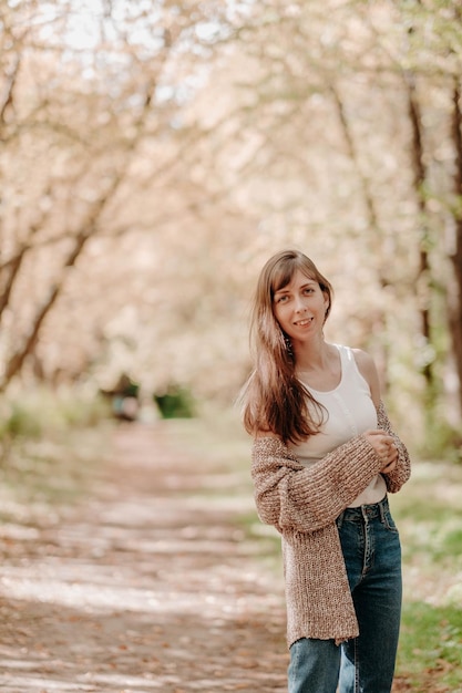 Retrato de uma menina de cabelo castanho em um casaco de lã em uma caminhada na floresta