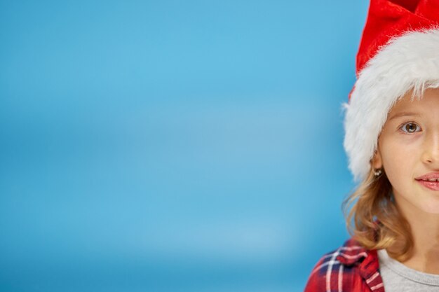 Retrato de uma menina de natal com chapéu de papai noel, sorrindo