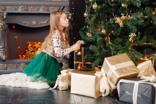 Retrato de uma menina decorando a árvore de Natal