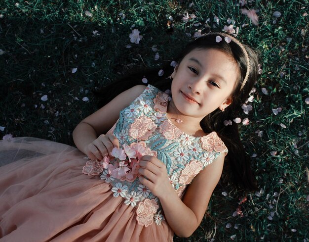 Retrato de uma menina deitada no campo em alto ângulo