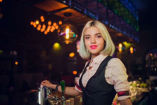 Retrato de uma menina em um bar à noite, atrás do balcão.