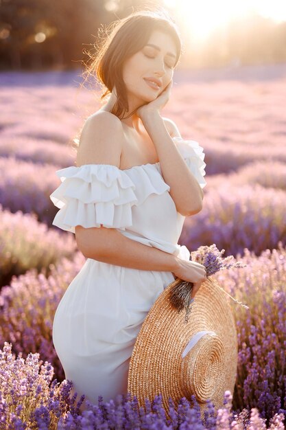 Foto retrato de uma menina em um campo de lavanda segurando flores de lavanda violeta