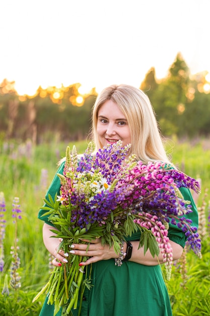 Retrato de uma menina em um campo florido ao sol ao pôr do sol