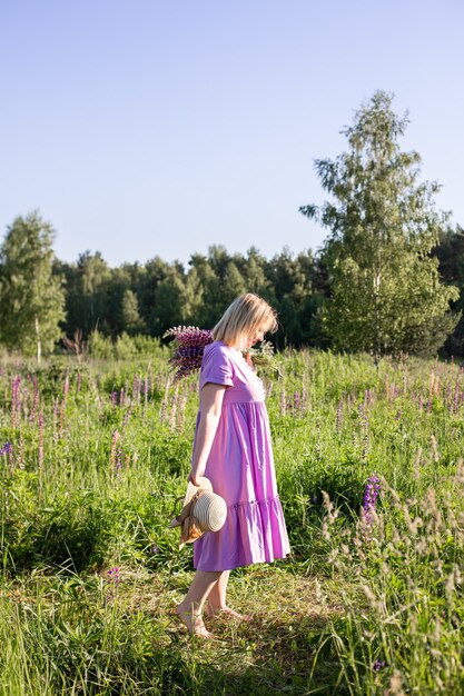 Retrato de uma menina em um campo florido ao sol ao pôr do sol