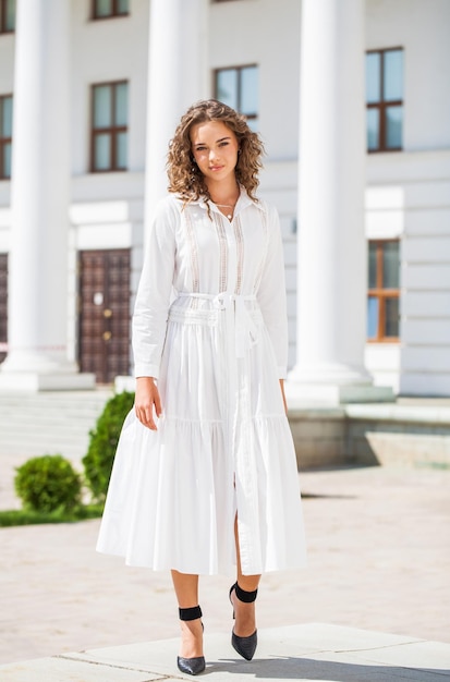 Retrato de uma menina em um vestido branco posando contra o fundo da Catedral Ortodoxa