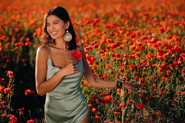 Retrato de uma menina em um vestido em um campo de papoulas ao pôr do sol