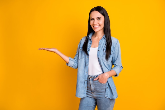 Retrato de uma menina encantadora e alegre segurando um espaço vazio em branco de cópia da palma da mão