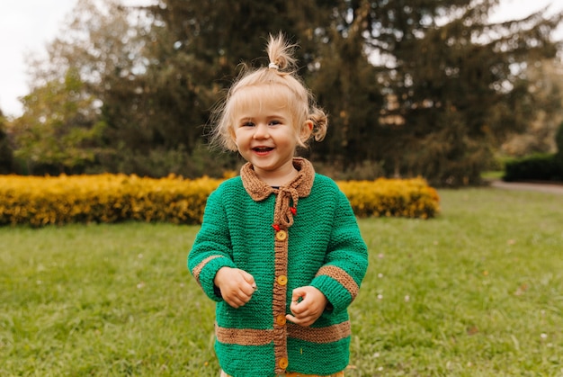 Retrato de uma menina feliz com roupas de outono. a criança ri no contexto da natureza.