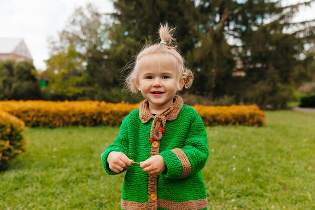 Retrato de uma menina feliz com roupas de outono. a criança ri no contexto da natureza.