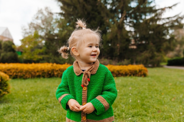 Retrato de uma menina feliz com roupas de outono. a criança ri no contexto da natureza.