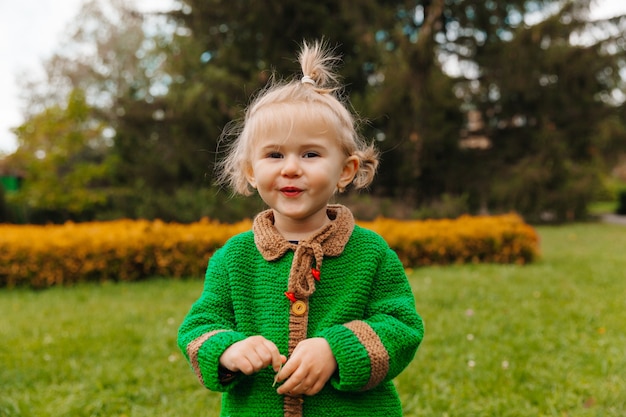 Retrato de uma menina feliz com roupas de outono. a criança ri no contexto da natureza.