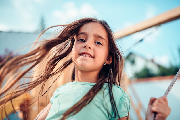 Retrato de uma menina feliz em um balanço