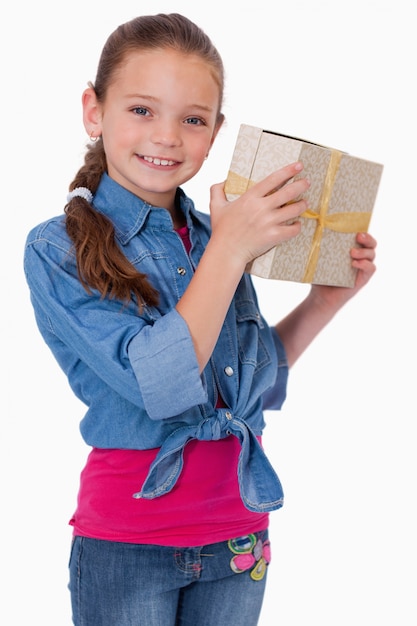 Retrato de uma menina feliz segurando uma caixa de presente