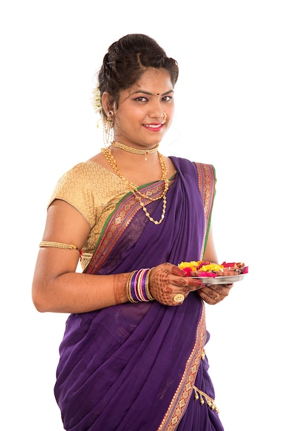 Retrato de uma menina indiana tradicional segurando pooja thali com diya