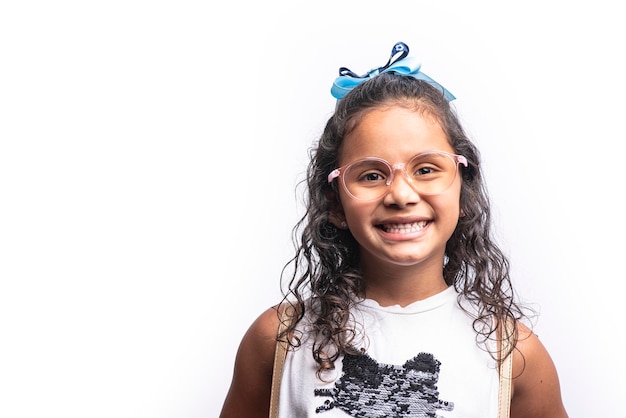 Retrato de uma menina latina sorridente com óculos olhando para a câmera em um fundo branco