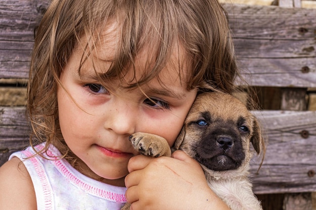 Retrato de uma menina linda de cabelos encaracolados com um cachorrinho