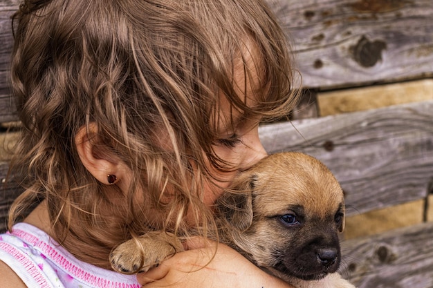 Retrato de uma menina linda de cabelos encaracolados com um cachorrinho