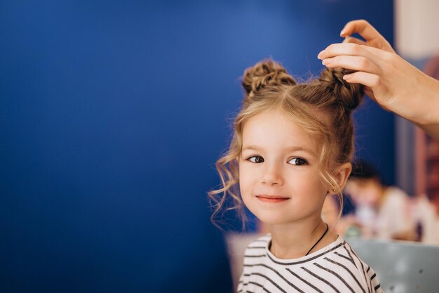 Retrato de uma menina linda em um salão de beleza O processo de fazer o cabelo de uma criança