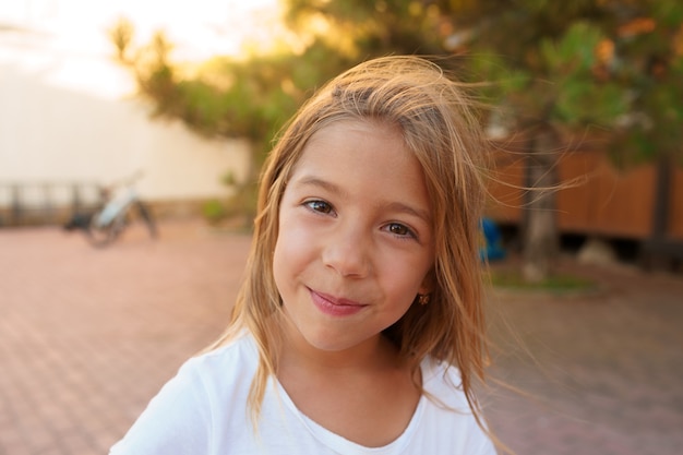 Retrato de uma menina loira olhando para a câmera