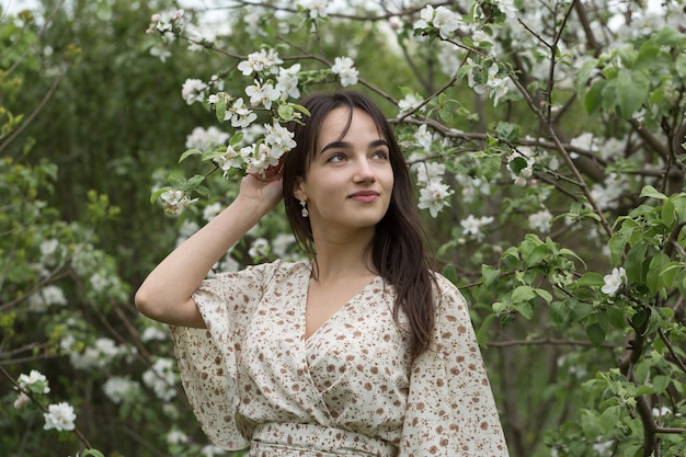 Retrato de uma menina morena alegre positiva em um parque verde primavera