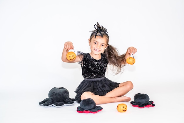 Foto retrato de uma menina morena com um chapéu preto e vestido preto em decorações de halloween.
