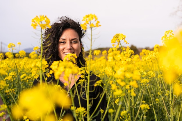 Retrato de uma menina na primavera em um campo de flores amarelas