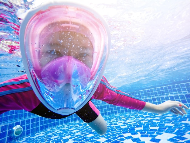 Foto retrato de uma menina nadando debaixo d'água na piscina